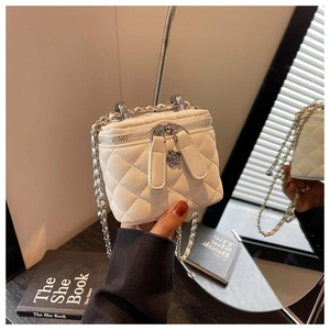 Detail der gesteppten weißen Mini-Tasche mit Silberkette und Kamelienblüten-Anhänger