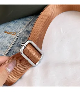 Detail of durable brown nylon shoulder strap with adjustable silver metal buckle hardware