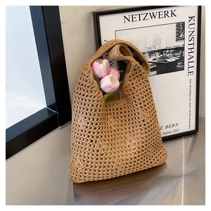 Detail of khaki crochet tote bag with honeycomb knit pattern and integrated strap