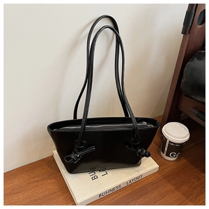 Détail du sac cabas noir brillant avec bretelles nouées et fermeture éclair argentée