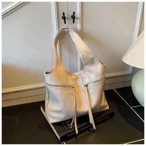 Détail du grand sac cabas avec poches avant zippées doubles et longs pompons décoratifs