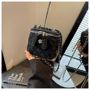 Detail der schwarzen gesteppten Mini-Tasche mit Goldkettenriemen und Blumendekor