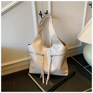 Détail du sac hobo en cuir brillant blanc crème avec de longues franges et fermetures