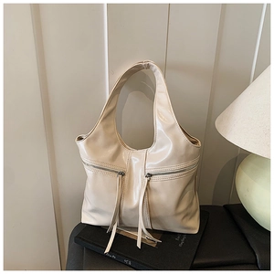 Détail du grand sac cabas blanc crème avec fermetures éclair et longs glands en cuir
