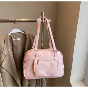 Detailed close-up of a pink faux leather shoulder bag with zipper and logo branding