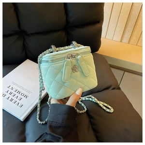 Details einer minzgrünen Stepptasche mit silberner Blumendeko und Kettenriemen