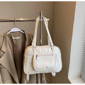 Detail of cream shoulder bag with Noronoro logo embossing and convenient front zipper pocket
