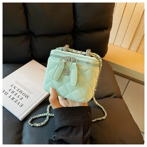 Nahaufnahme der minzgrünen Stepptasche mit silberner Blumenschnalle und Kettenriemen