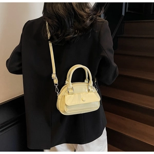 Model view of cream yellow bowling bag with top handles and adjustable strap
