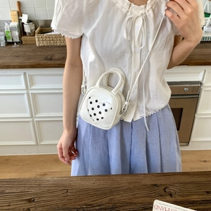Close-up of a white PU leather mini bucket bag with a heart-shaped polka dot pattern