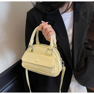 Detail of lemon yellow PU leather handbag with silver hardware and front flap pocket