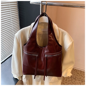 Détail du sac fourre-tout bordeaux avec doubles fermetures éclair et longs pompons