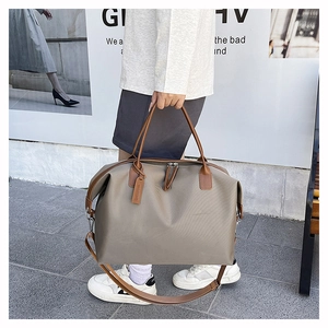 Close-up of grey large tote bag with leather handles shown in a street style setting
