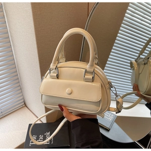 Detail of a beige PU Boston bag featuring a front flap pocket and elegant silver hardware