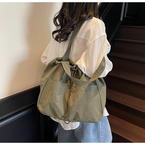 Detail of olive green large capacity drawstring tote bag with wide shoulder strap