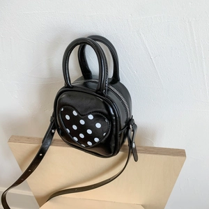 Detail view of mini bucket bag with polka dot heart pattern and metallic rivets