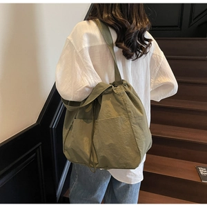 Detail of olive green large capacity tote bag with drawstring pocket in urban style