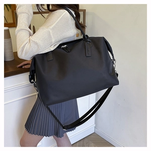Fashionable black large tote bag with top handles and adjustable shoulder strap for travel