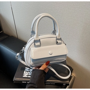 Close-up of glossy light blue patent leather handbag with silver hardware and front flap pocket