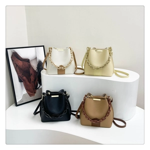 Collection de sacs seaux texturés en blanc, beige, noir et marron avec détails dorés