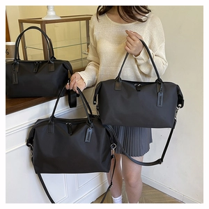 Close-up of black waterproof nylon tote bag with reinforced handles and shoulder strap