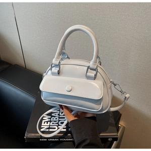 Detail of light blue mini bowling bag with smooth synthetic leather and silver hardware