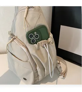 Detail of beige nylon crossbody bag showing spacious side pocket with drawstring closure