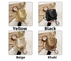 Collage de sacs seaux en cuir jaune, noir, beige et kaki avec détails de chaîne en résine