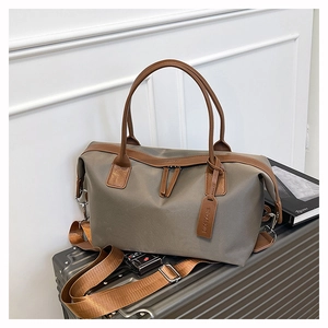 Detail of Wholesome leather tag and double zippers on the khaki large tote travel bag