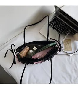 Intérieur spacieux du sac à main noir avec froufrous roses montrant le rangement quotidien