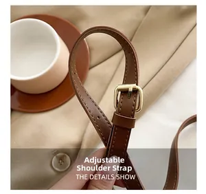 Détail de la bandoulière réglable en cuir marron avec boucle dorée et coutures fines