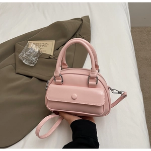 Detail view of a pink PU leather mini pillow bag with silver hardware and top handles
