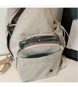 Detail showing spacious beige nylon crossbody bag interior with striped lining and pockets