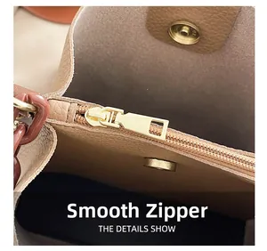 Détail de la fermeture éclair dorée lisse et du cuir grainé sur ce sac beige chic