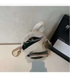 Detail view of the spacious open interior and striped lining of this off-white crossbody bag