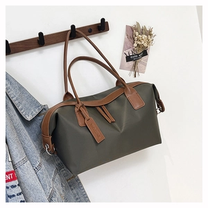 Macro detail of large dark green tote bag with premium brown leather handle and tag