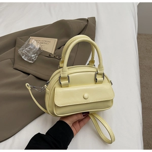 Detail of cream yellow mini pillow bag with smooth PU leather and top handle