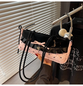 Sac sous le bras rose matelassé avec froufrous noirs et pendentif cœur en métal