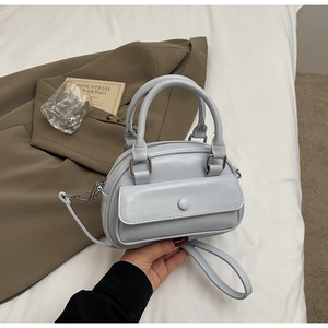 Close-up of light blue bowling handbag with front pocket and detachable shoulder strap
