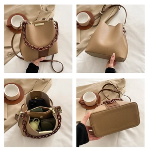 Détails du sac seau marron montrant le cuir texturé, la poignée chaîne et l'intérieur