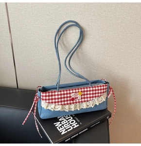 Détail du sac sous le bras en denim bleu avec rabat vichy rouge et bordure en dentelle