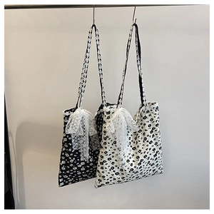 Vue détaillée de sacs cabas en toile florale avec nœuds dentelle et anses assorties