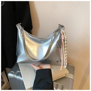 Close-up of silver oil wax leather shoulder bag with tennis racket charm and metal logo