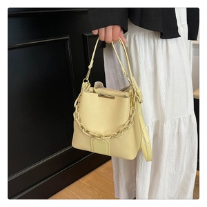 Vue détaillée d'un sac seau crème avec chaîne et texture en cuir grainé élégant