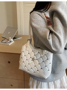 Weiße Stepptasche mit silbernen Sternnieten und Kettenriemen in minimalistischem Lifestyle