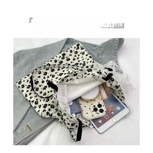 Vue détaillée du sac cabas en toile fleurie montrant sa capacité pour tablette et objets