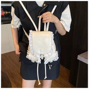 Detail of white PU backpack with delicate lace trim and silver hardware on a model