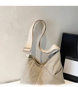 Detail of adjustable wide smooth shoulder strap on minimalist cream fabric triangle tote bag