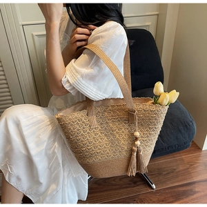 Detail of straw woven tote bag with wooden bead tassel and interior tulip floral accent