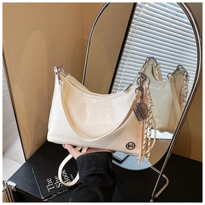 Detail of cream oil wax leather crescent bag with metal M logo and woven zipper puller